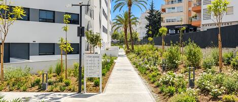 Un sendero bordeado de vegetación y un cartel que indica las direcciones a diferentes lugares.