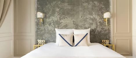 Habitación de hotel con una cama grande, dos mesitas de noche y un cabecero decorativo.