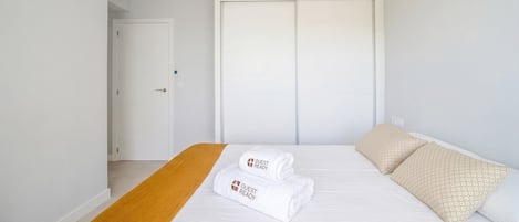 A hotel room with a bed, a ceiling fan, and a wardrobe.