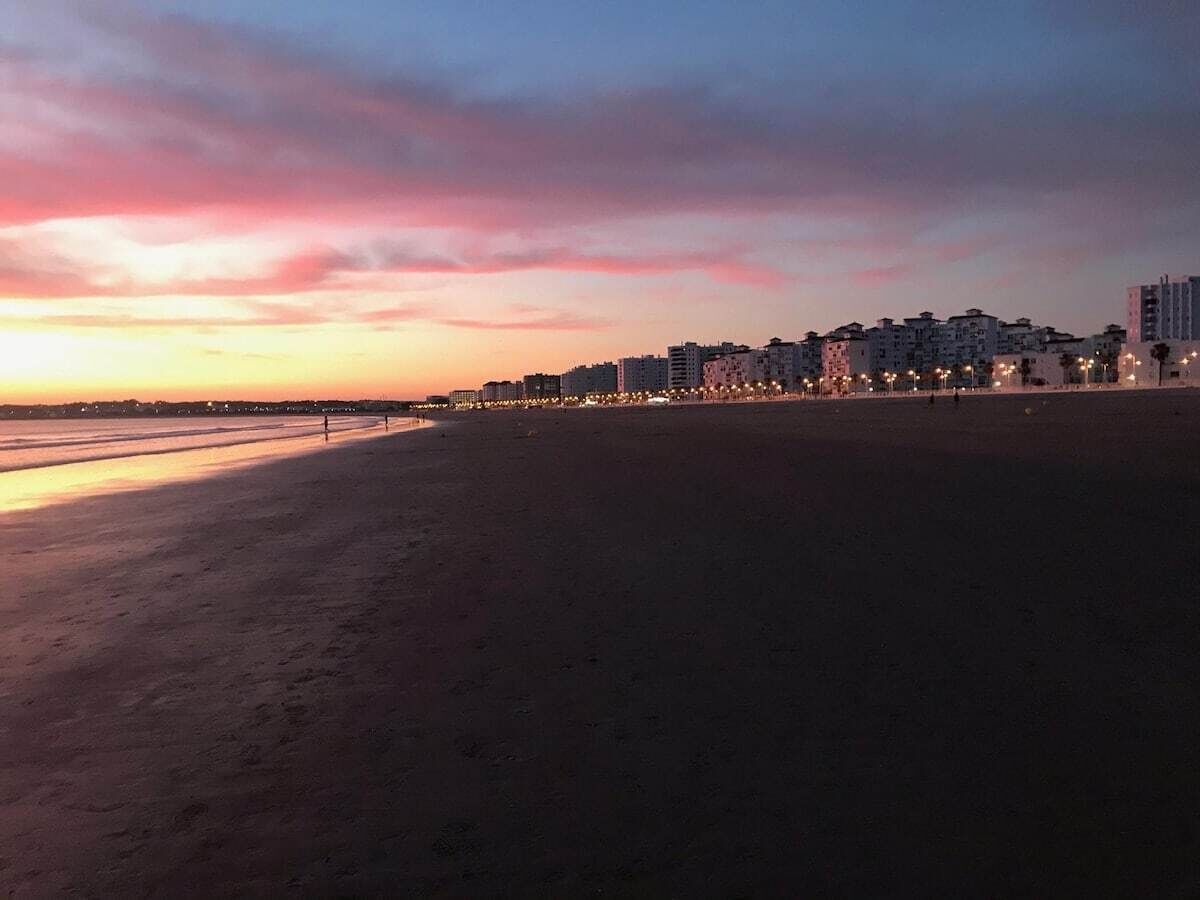 A beach with a row of buildings in the background.