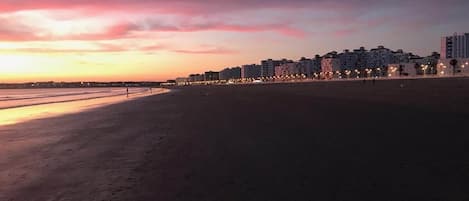 A beach with a row of buildings in the background.