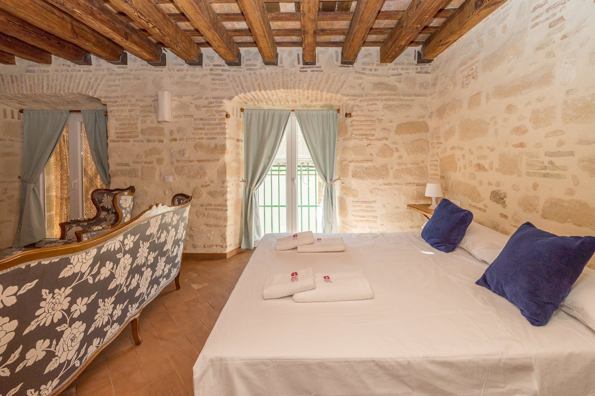 Une chambre avec un lit, un bureau et une fenêtre avec des rideaux.