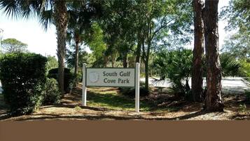 Schild für den South Gulf Cove Park, umgeben von Bäumen und Grün.