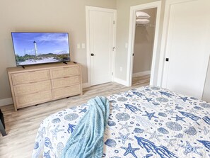 Um quarto com uma cama, uma televisão em uma cômoda e um guarda-roupa.