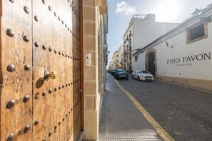 Straßenansicht mit einer Holztür und einem Gebäude mit der Aufschrift 'Fino Pavon'.