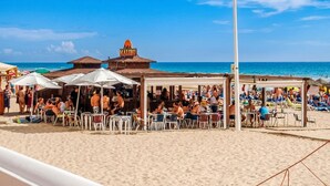 En restaurang vid stranden med uteservering och utsikt över havet.