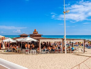 Ein Restaurant direkt am Strand mit Außenbereich und Meerblick.