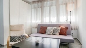 Ett modernt vardagsrum med en soffa, ett bord och en lampa.