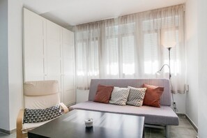 Ein modernes Wohnzimmer mit einer Couch, einem Tisch und einer Lampe.