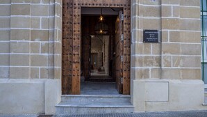 A building entrance with a wooden door and a sign indicating it is a tourist apartment building. - GuestReady - La Cruz Bajo A (El Puerto de Santa María)