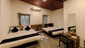 Habitación de hotel con dos camas, un escritorio y un espejo.