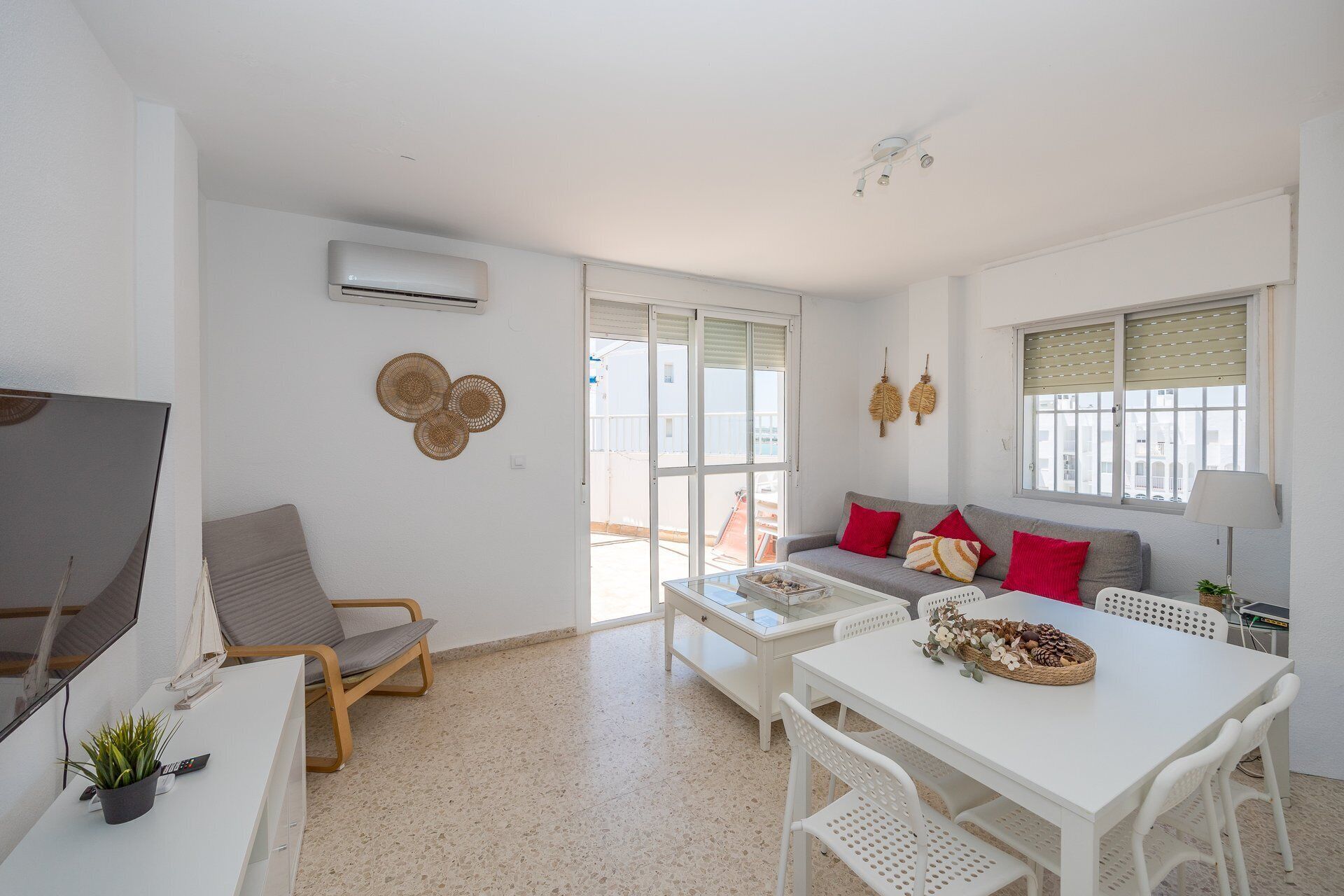 Una sala de estar moderna con un sofá, una mesa de comedor y un televisor.