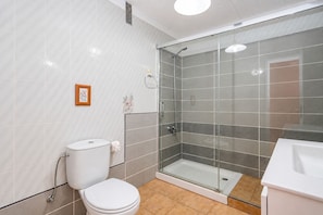 Un baño moderno con inodoro, ducha y lavamanos.