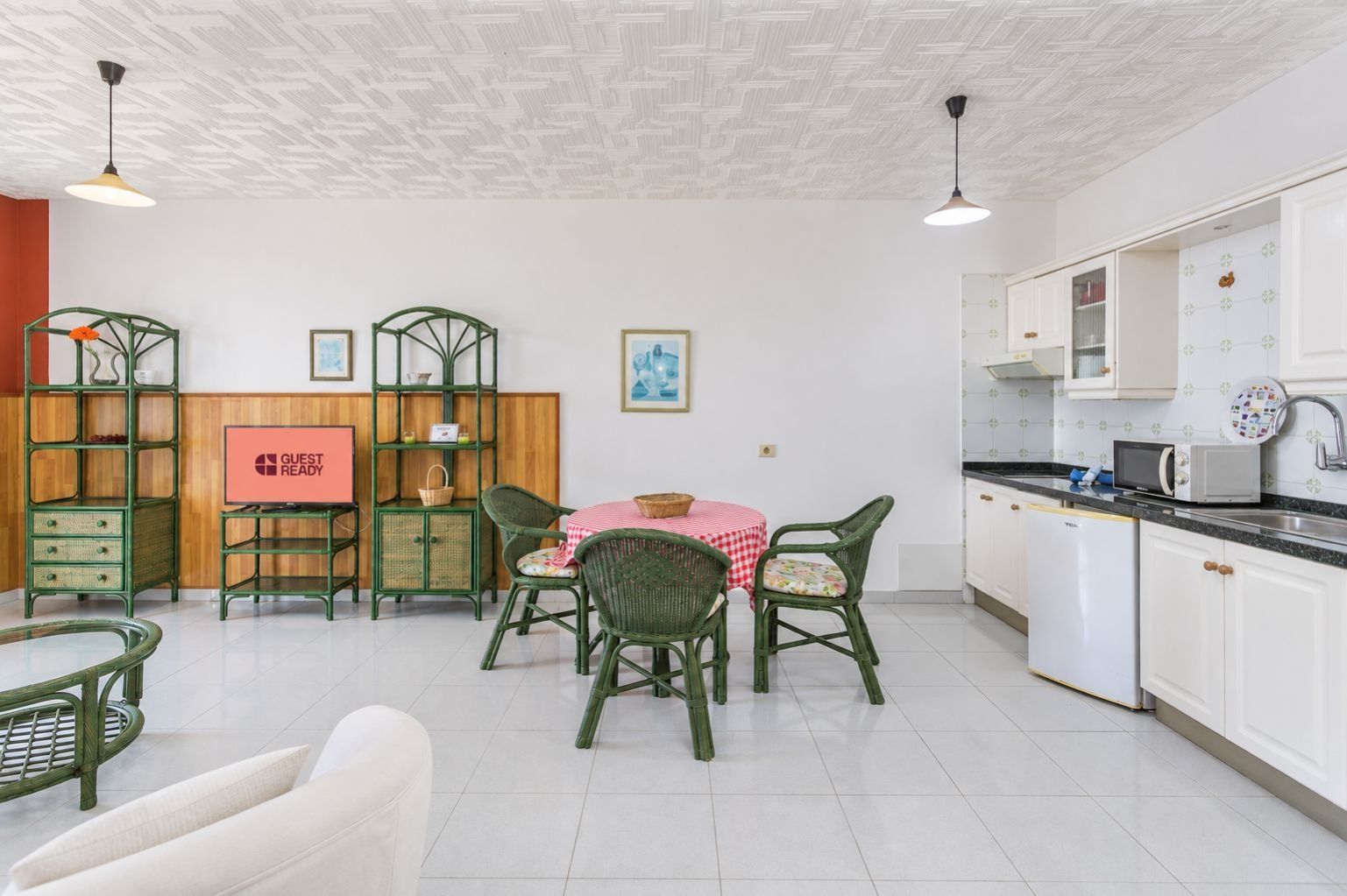 Una habitación con comedor, cocina y un letrero que indica lista para huéspedes.
