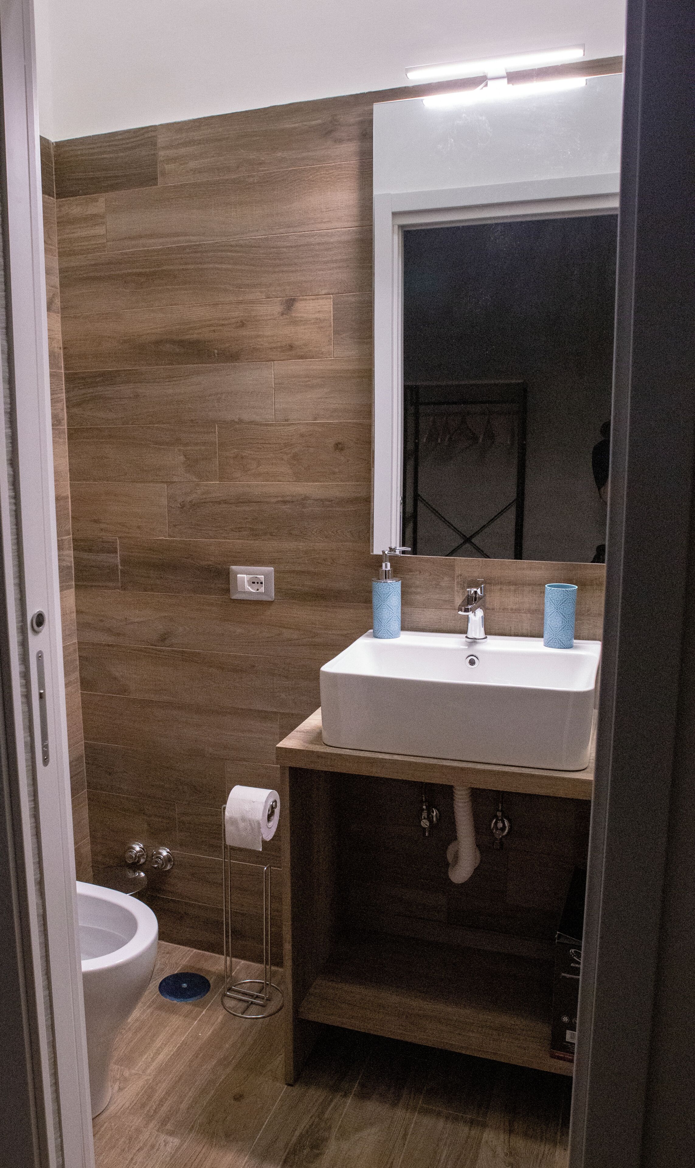A bathroom with a white sink, a mirror, and a toilet.