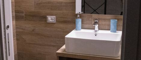 A bathroom with a white sink, a mirror, and a toilet.