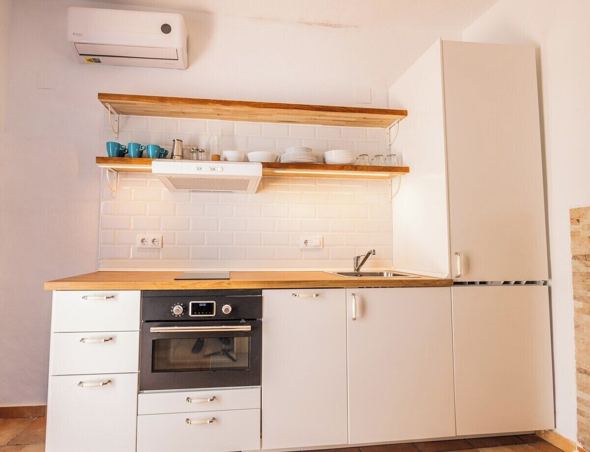 A compact kitchen with a built-in oven, a dishwasher, and a refrigerator.