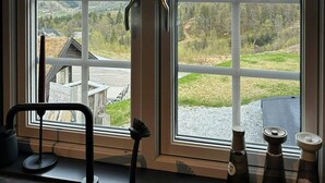 A room with a large window offering a view of a mountainous landscape.