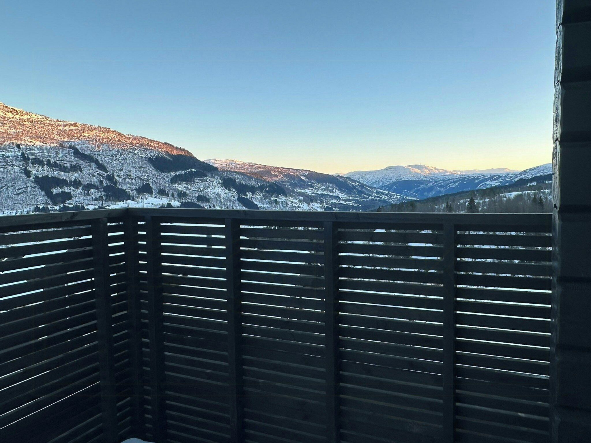 Un balcón con vista a montañas nevadas.