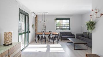 Un espacio moderno para vivir con comedor, sofá y vistas al exterior.