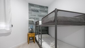 Una cama litera en una habitación con una pared que muestra nombres de ciudades.