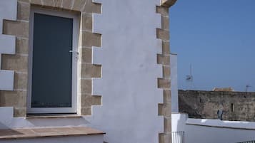 Ein Gebäude mit heller Fassade, einem Rundfenster und einer Steintreppe, die zu einer Tür führt.