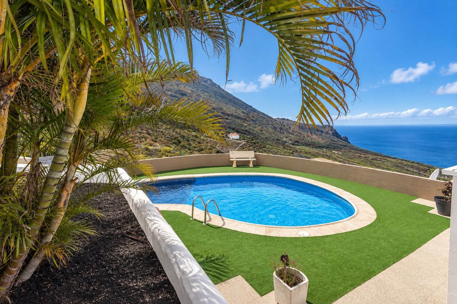 Una piscina con vistas al océano y una montaña al fondo.