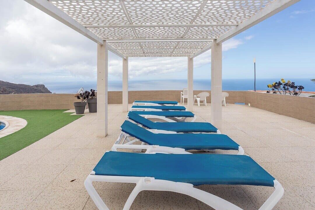 Un espace extérieur aménagé, abrité et doté de chaises longues, d’un petit jardin et d’une vue sur la mer.