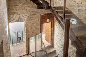 A staircase leading to a balcony with a view of a courtyard. - GuestReady - La Cruz 2C (El Puerto de Santa María)