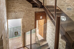 Ein modernes Interieur mit Treppe, einer Holztür und Blick ins Freie.