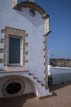 Ein Gebäude mit weißer Fassade, einem Rundfenster und einer Tür mit Fenster.