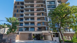A multi-story residential building with a gated entrance, balconies, and a sign indicating the name 'FIS'.