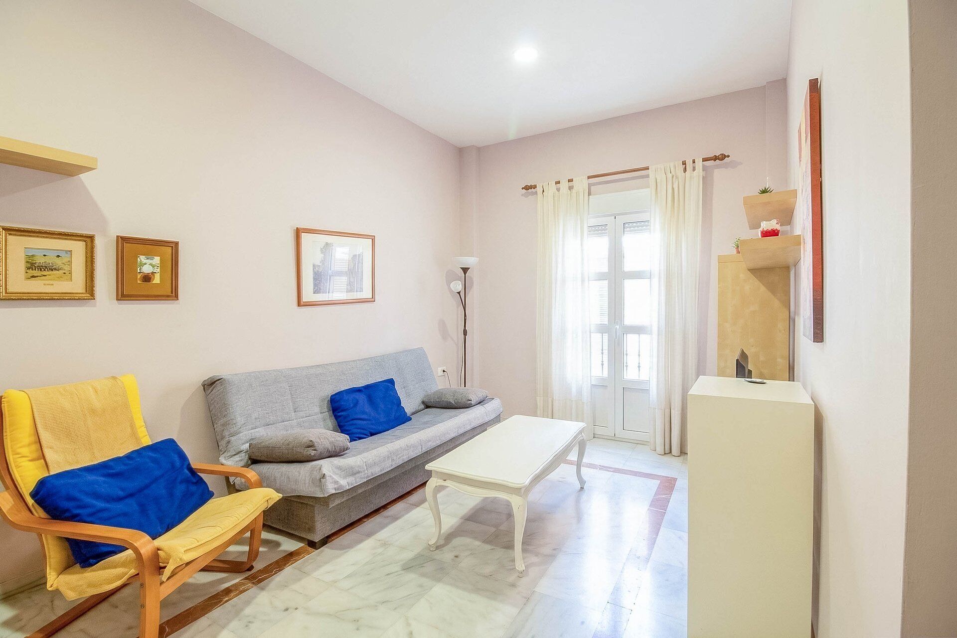 Un salon comprenant un canapé, un fauteuil, une table basse et un meuble.