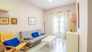 Un salon comprenant un canapé, un fauteuil, une table basse et un meuble.