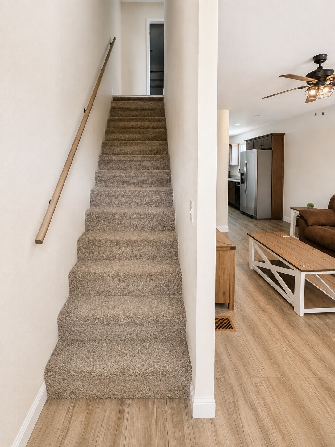 A staircase with carpeted steps leading to a hallway.