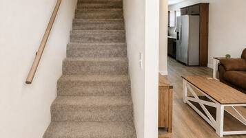 A staircase with carpeted steps leading to a hallway.