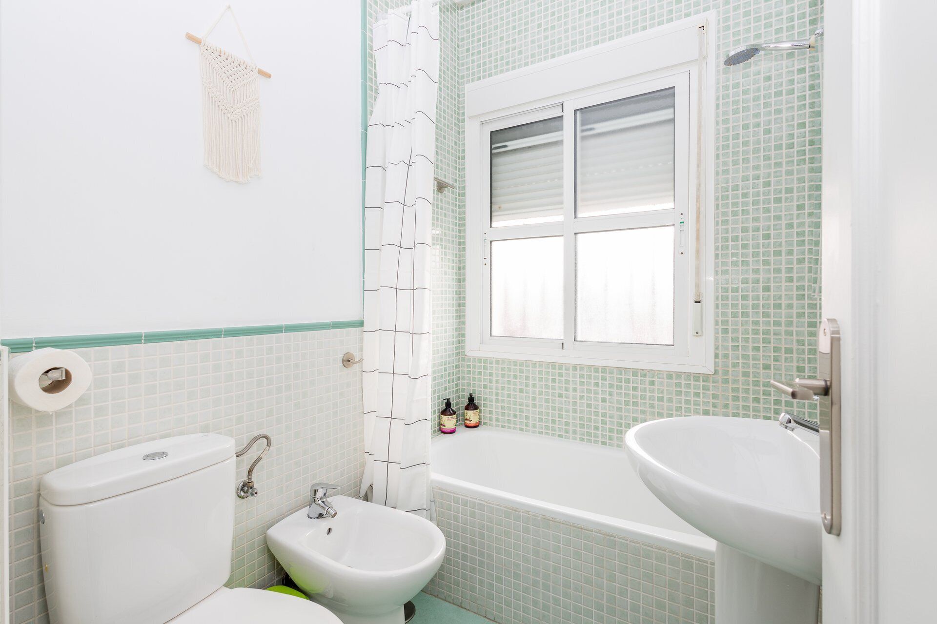 Un baño con inodoro, bidé, bañera y dos lavamanos.