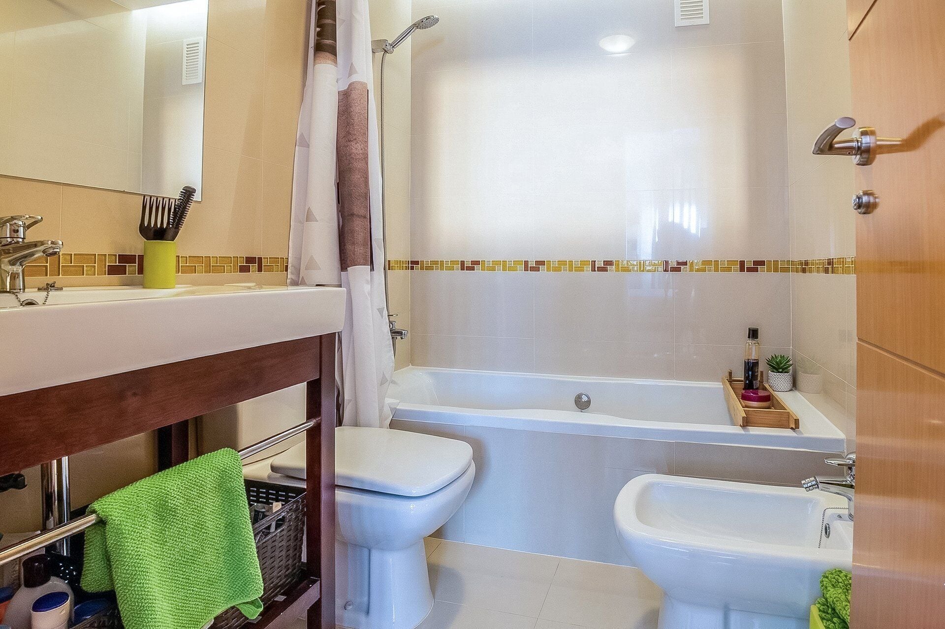 A bathroom with a sink, toilet, bidet, and bathtub.