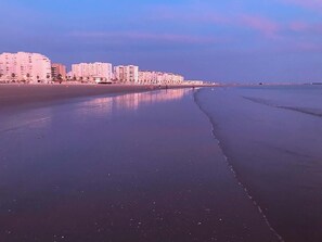 A beach with a row of buildings along the shore. - GuestReady - Valdelagrana Nacita (El Puerto de Santa María)