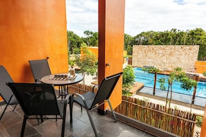 A balcony with a table, chairs, and a view of a swimming pool. - 3BR Tulum Retreat with Private Terrace (Tulum)