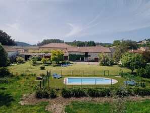 A residential property with a swimming pool, multiple lounge chairs, and a well-maintained lawn. - Casa de Requeixo - 4-bedroom vacation home with a shared pool (Povoa De Lanhoso)