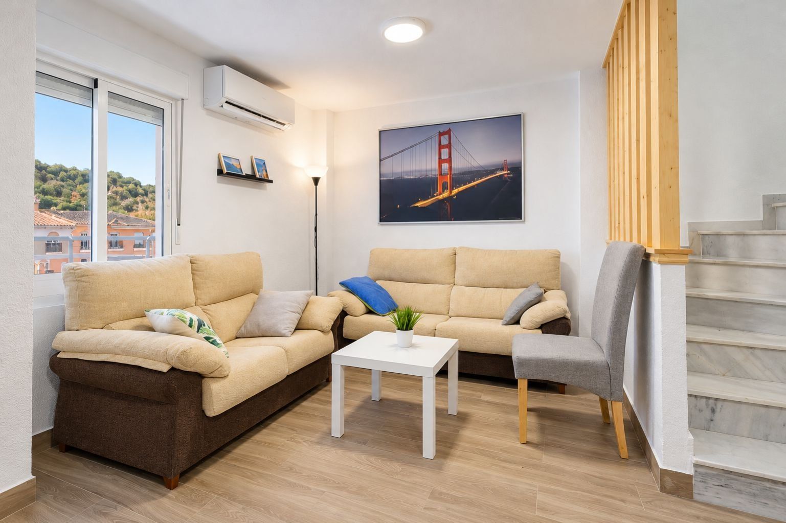 Ein Wohnzimmer mit einer Couch, einem Couchtisch und einer Treppe.