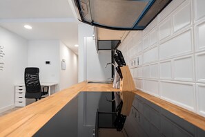 A modern kitchen with a wooden countertop, a sink, and a knife block. - GuestReady - Beach Escape by Cancajos (Breña Baja)