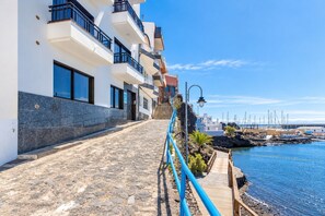 Un edifici marítim amb un camí empedrat de pedra que condueix a una zona de moll amb barques.
