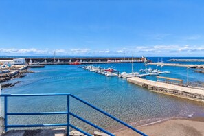 Un port esportiu amb vaixells amarrats, un moll i un cel blau clar.