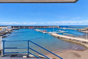 A marina with boats docked, a pier, and a clear blue sky. - GuestReady - Charming Beachfront Apartment (La Restinga)