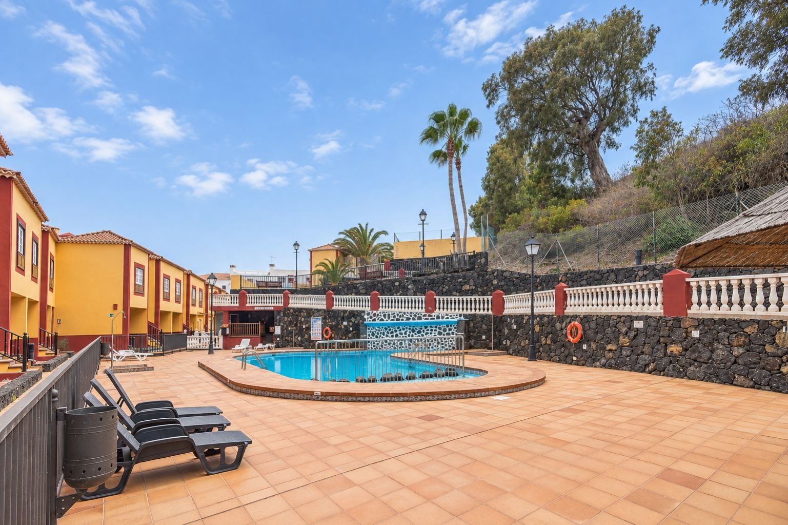 Una piscina amb gandules i una paret de pedra.