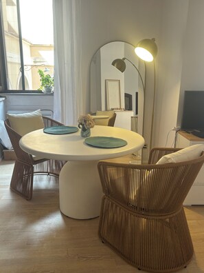 Ein Essbereich mit Korbstühlen, einem runden Tisch und einer Stehlampe.