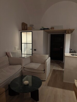 Ein modernes Wohnzimmer mit einer Couch, einem Sessel und einem kleinen Couchtisch.