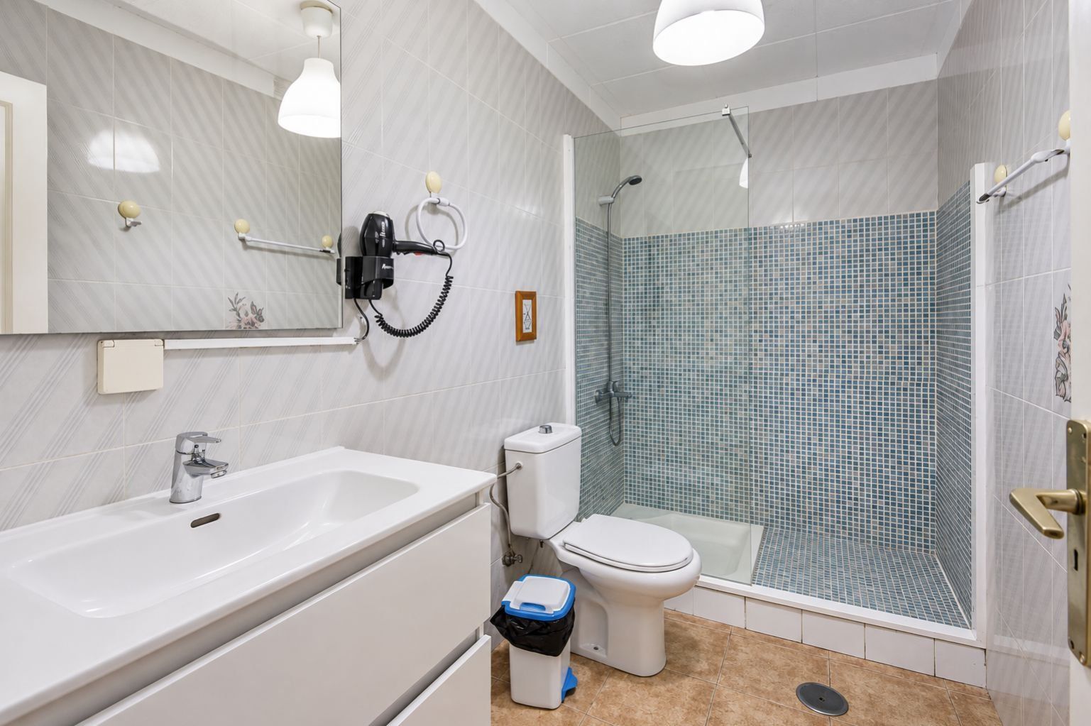 Ein modernes Badezimmer mit Waschbecken, Toilette und Duschbereich.